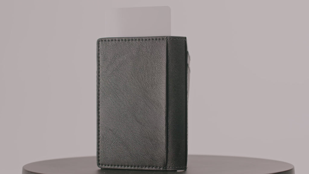 360-degree video of a slim, sliding wallet in black leather holding one card, rotating against a clear background.