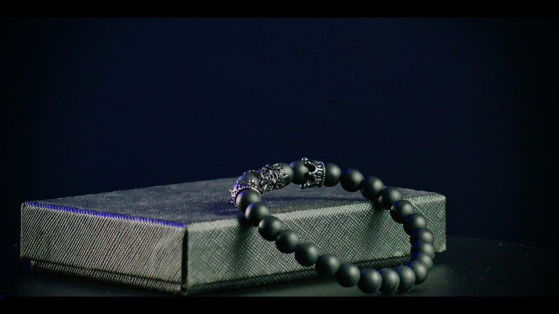 Luxurious minimalist black hematite bracelet on a sleek dark background, symbolizing elegance and sophistication.